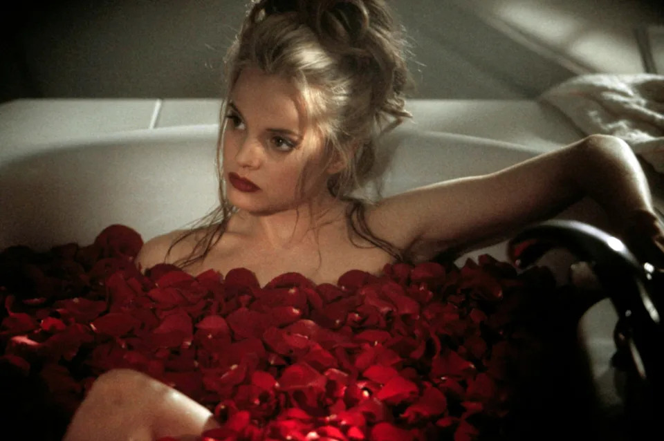 Mena Suvari in a bathtub filled with rose petals