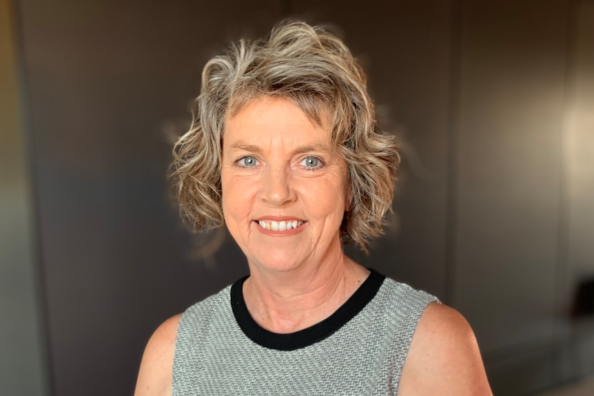 Simone smiles as she stands inside.