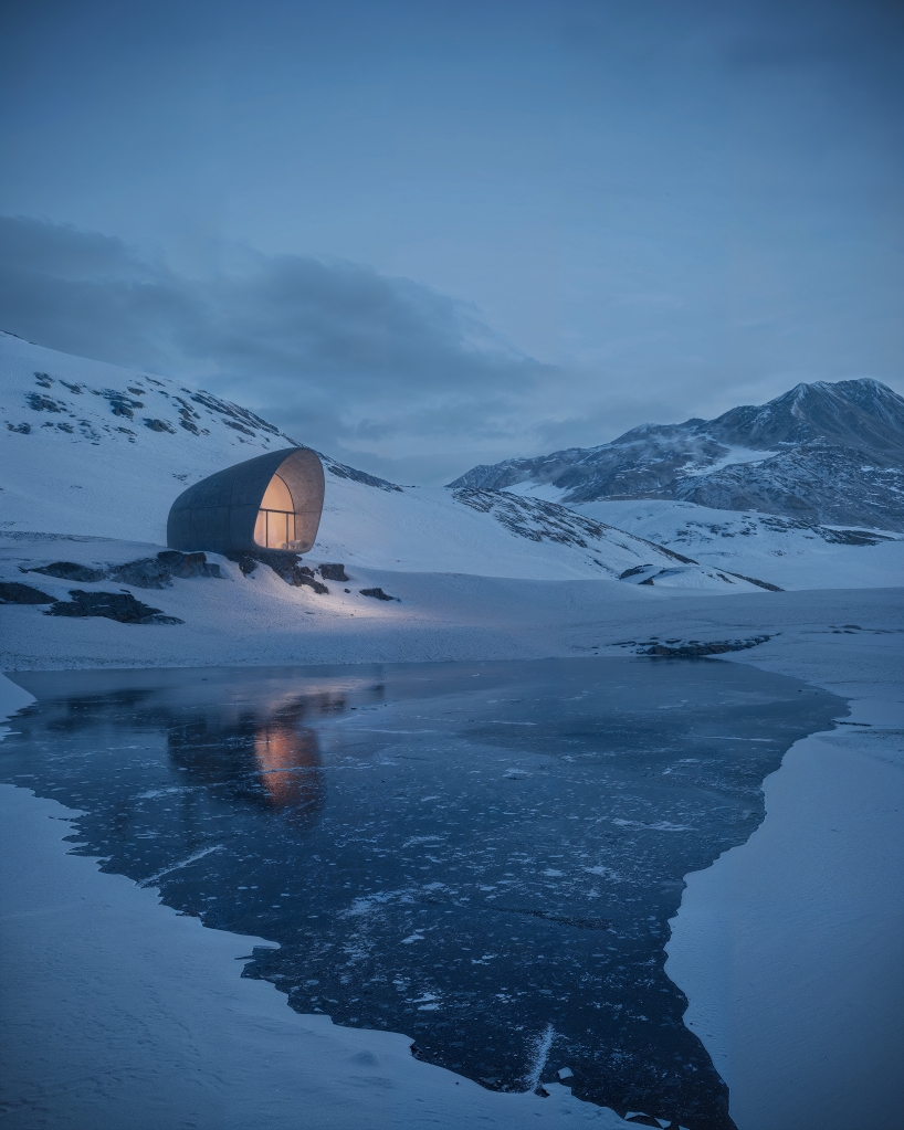 high-altitude cottage emerges like a rock from georgian mountains