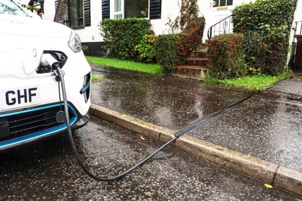 An electric car charging using a Kerbo Charge cross-pavement solution