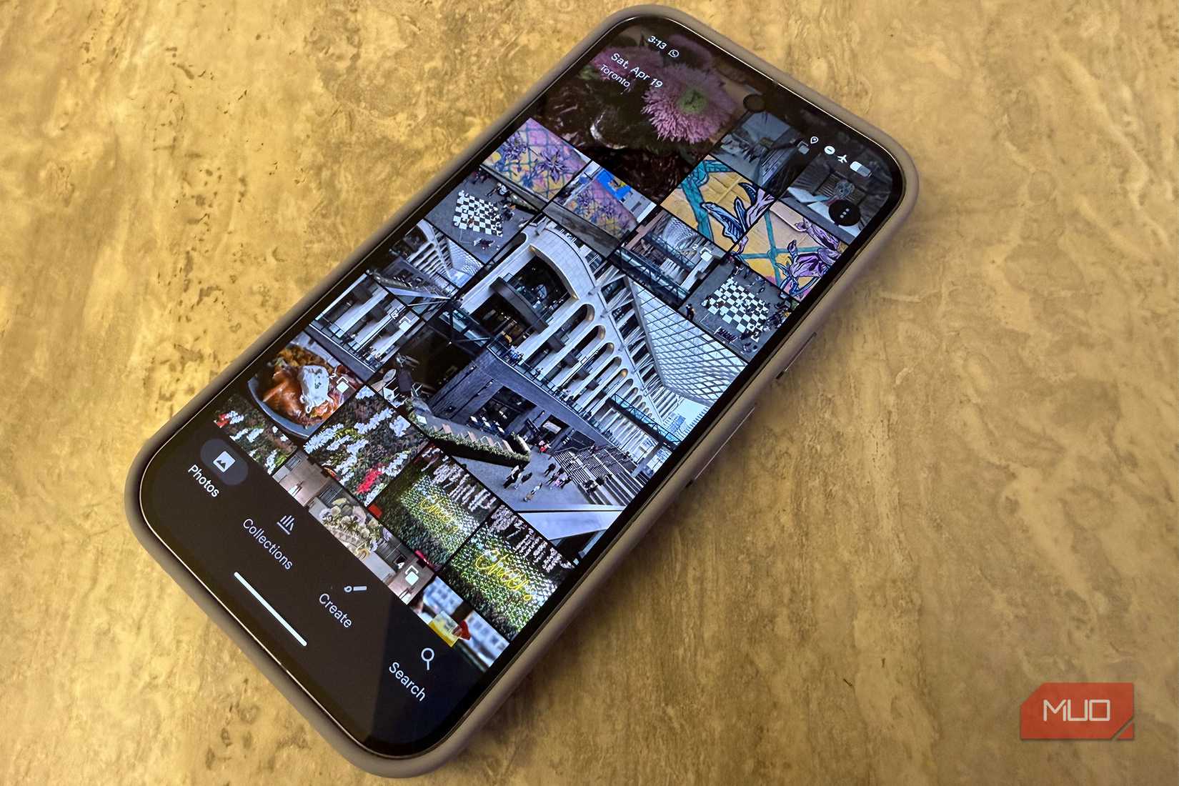 An Android phone on a table showing a photo library.