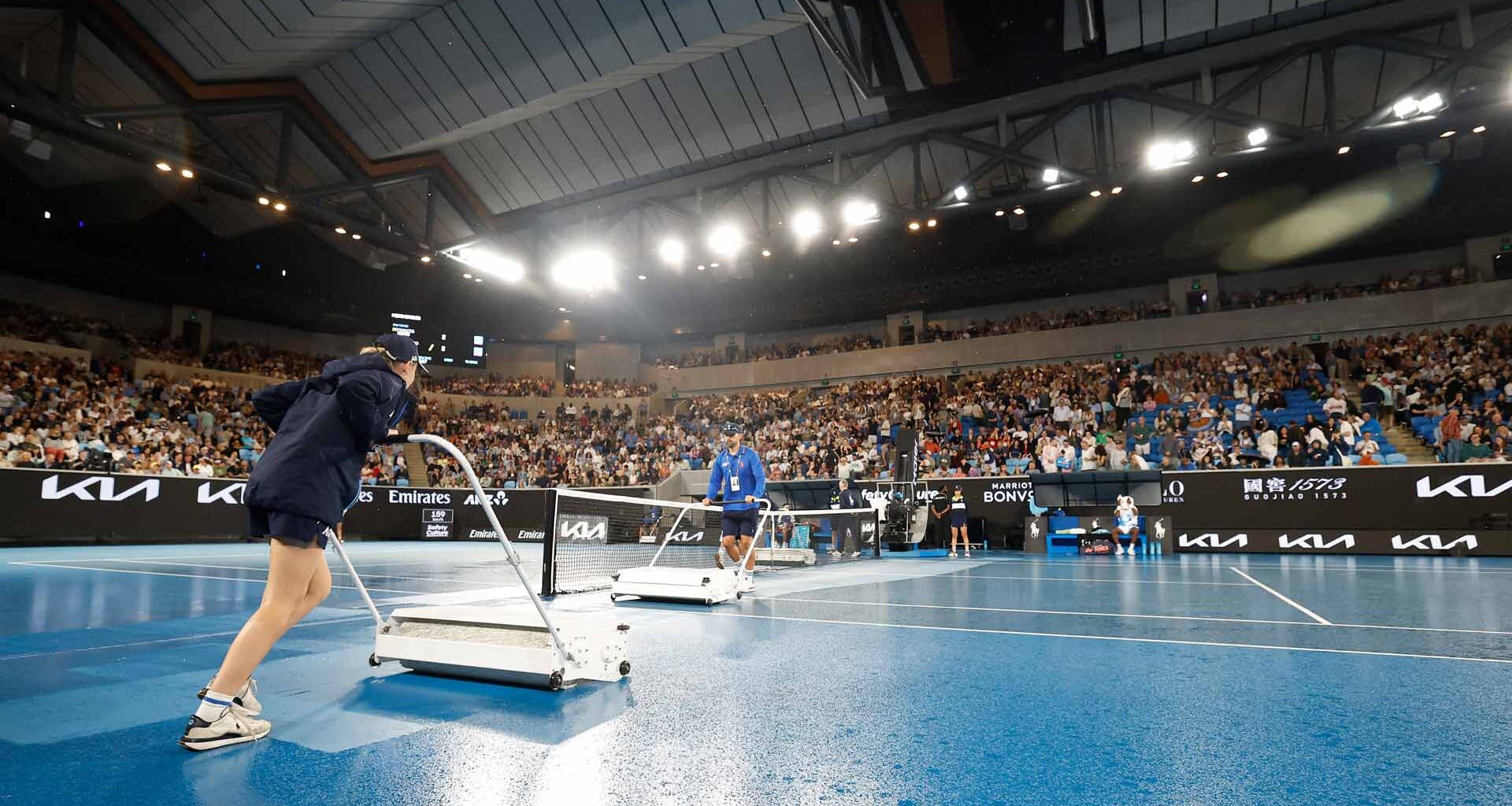 Ball kids dry a court at the Australian Open on Wednesday evening.