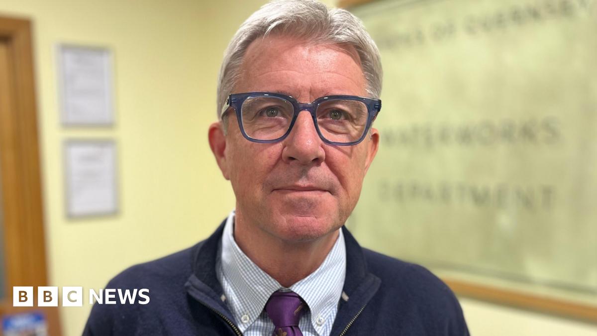 Deputy Mark Helyar - A man with grey hair, wearing blue spectacles. He has a blue jacket on with a blue and white checked shirt.