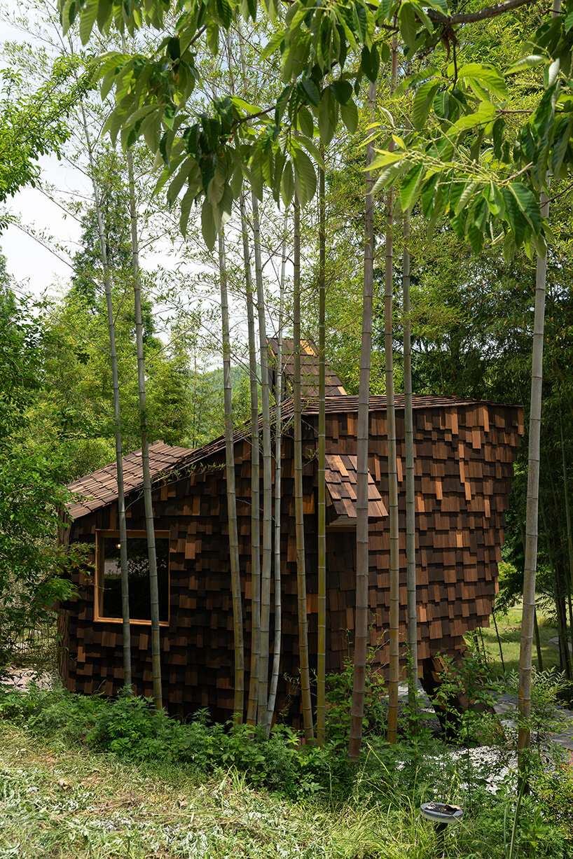 patchwork exterior of 'cat house' in china's anji forest is clad in discarded bamboo tiles
