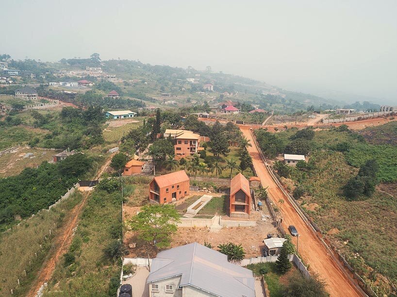 clay monolithic villas emerge from ghana’s red earth landscape
