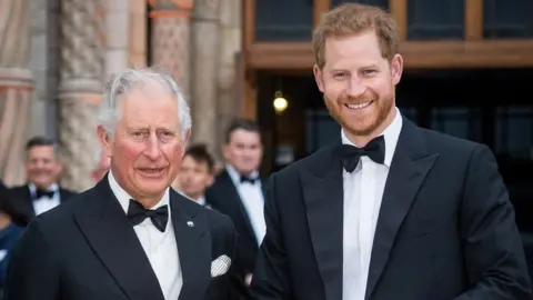 Getty Images Head and shoulders photo of then Prince Charles and Prince Harry in London in 2019. They are both wearing tuxedos and smiling at the camera. Harry is on the right