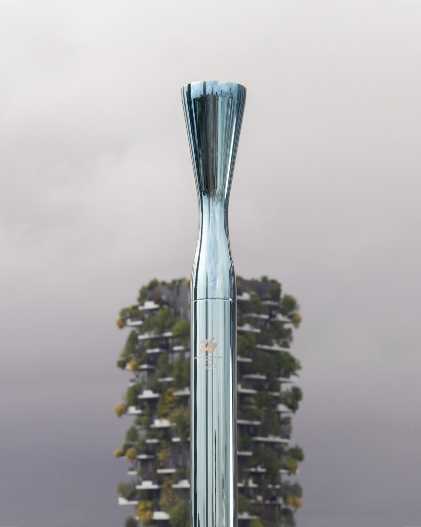Pale blue torch in front of plant-clad building