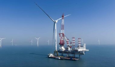 Massive offshore wind turbine being installed at sea near Hainan, with other turbines visible in the distance.