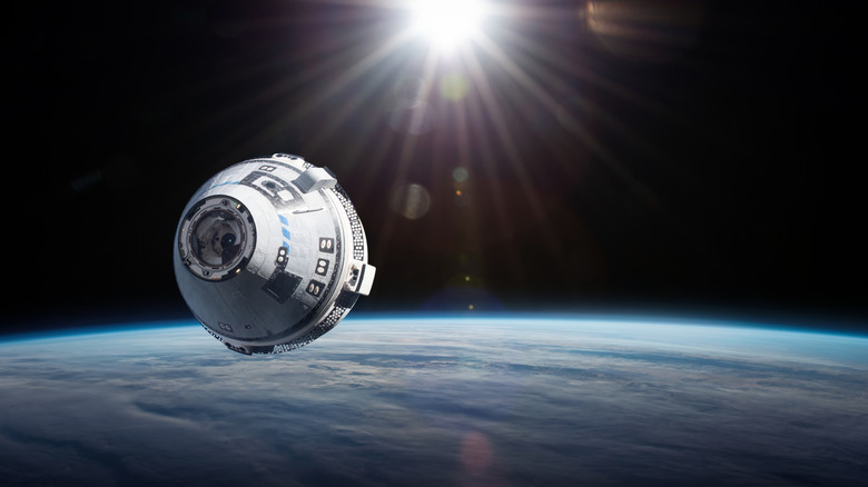 spacecraft like boeing starliner in space above the earth