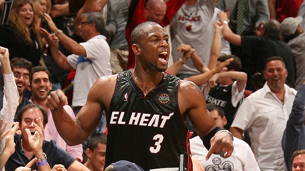 Dwyane Wade hyped up during game, seen on court with fans behind him.