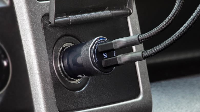 Two USB cords plugged into a Scosche PowerVolt car charger.