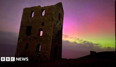 old caslte monumnet with purples and greens of the northern lights in the night sky