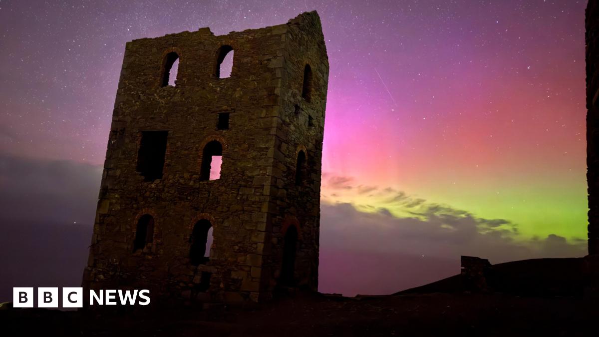 old caslte monumnet with purples and greens of the northern lights in the night sky