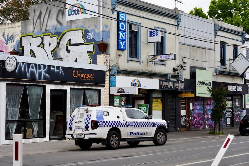 A police car pictured outside graffitied buildings in Victoria Street, Richmond