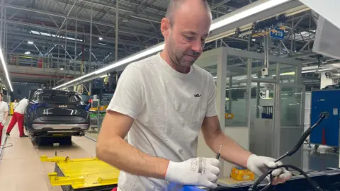 Kia assembly line worker Marcel Pukhon helping to build a car on a assembly line