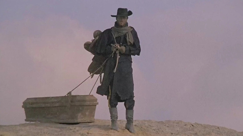 Django (Franco Nero) drags a coffin through the desert in Django (1966)