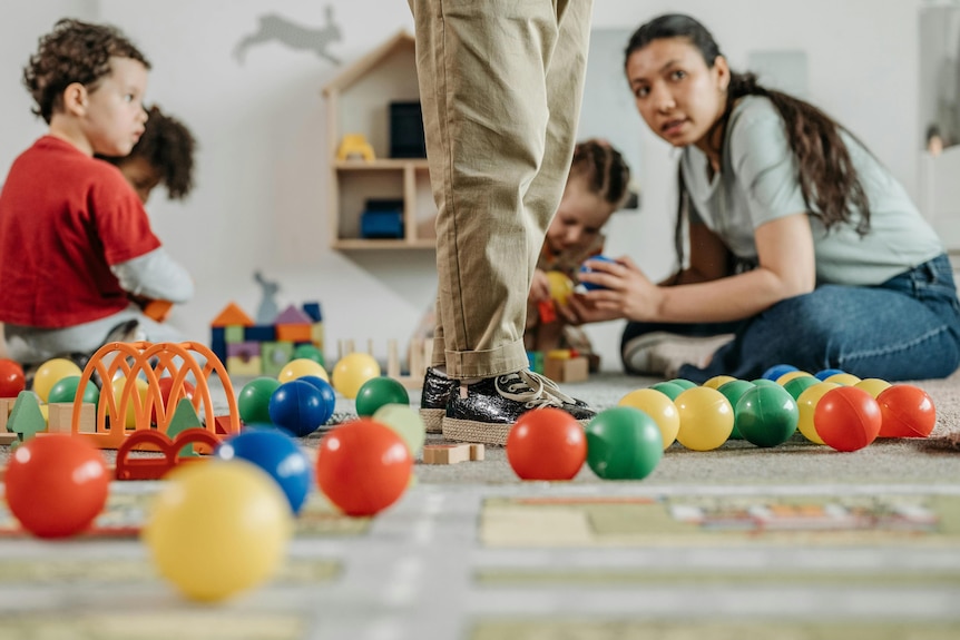 Children and educator playing on the floor