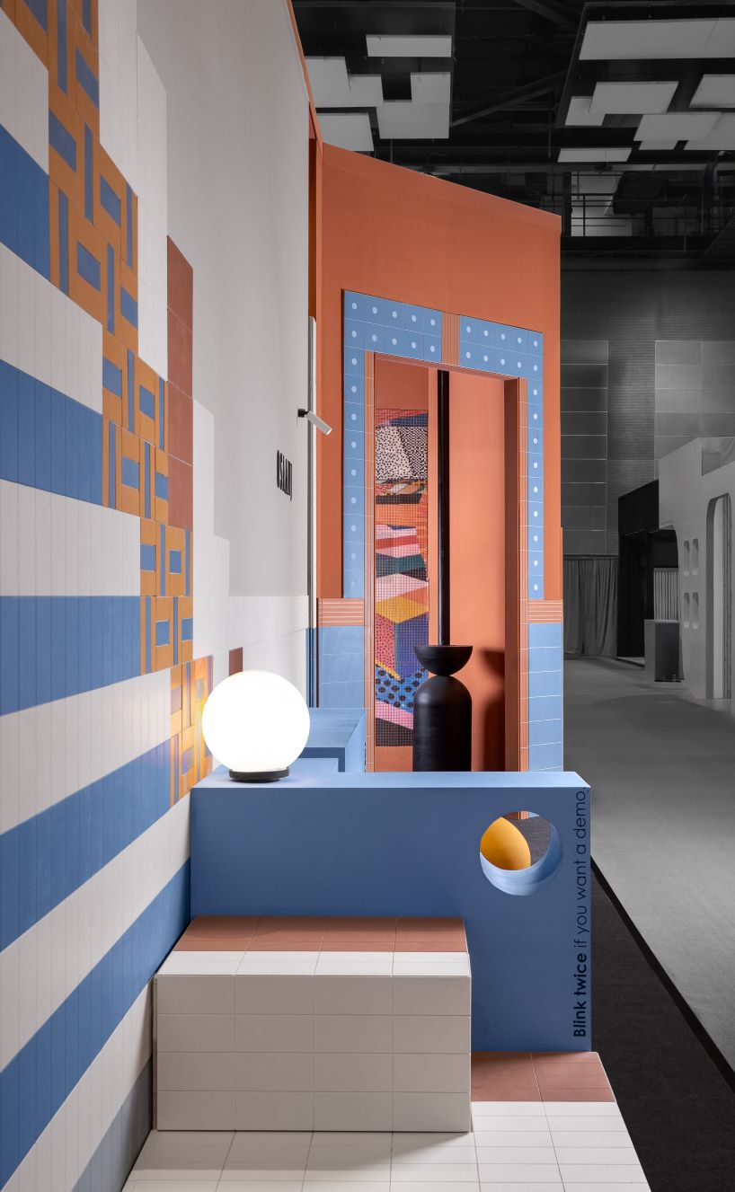 patterned tiles extend from curved walls to furniture in layered retail exhibition booth