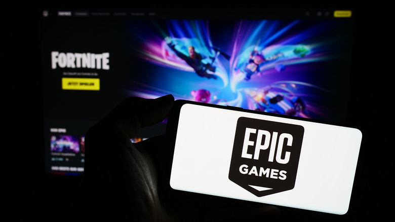 Epic Games logo on phone screen held in front of monitor