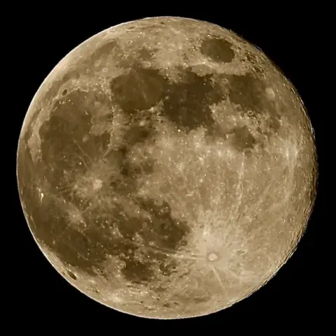 BBC Weather Watchers/Big Ted A close-up picture of a silvery-yellow moon with dark patches on a pitch black background