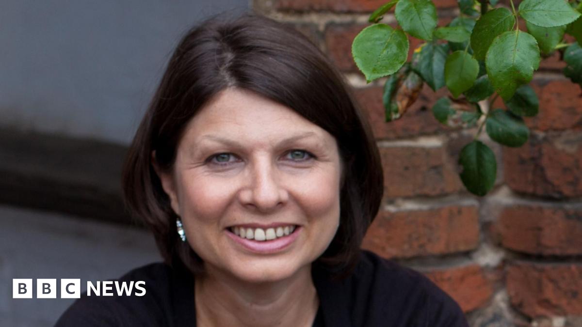 Prime Minister Mark Carney, wearing a black suit jacket, and a white button-up shirt leans his chin on his hands. He has short grey and black hair and is looking away from the camera.