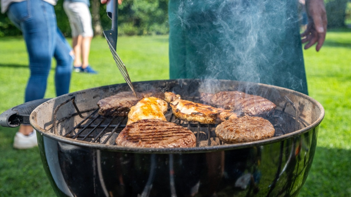 Man flipping meat on charcoal grill