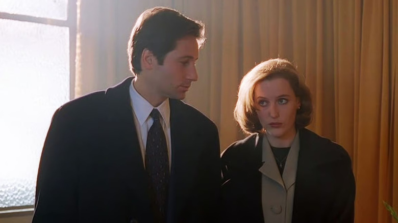 David Duchovny as Fox Mulder looking at Gillian Anderson as Dana Scully in The X-Files