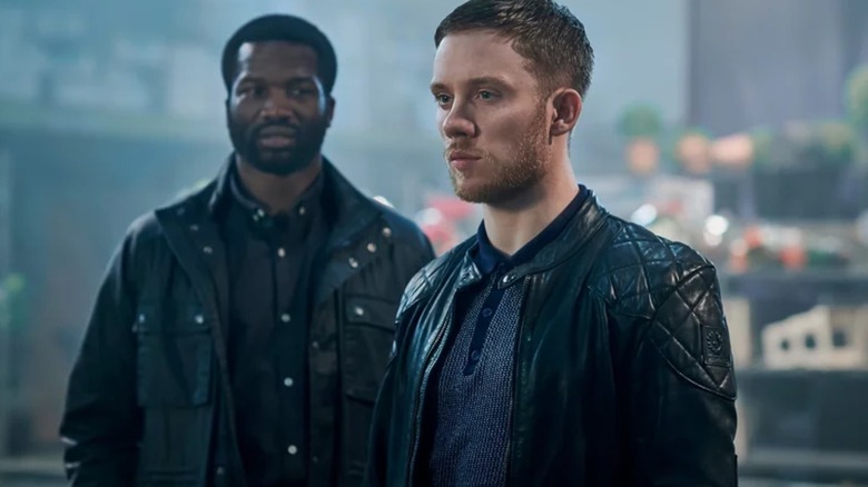 Elliot Carter (Sope Dirisu) stands behind Sean Wallace (Joe Cole) in Gangs of London