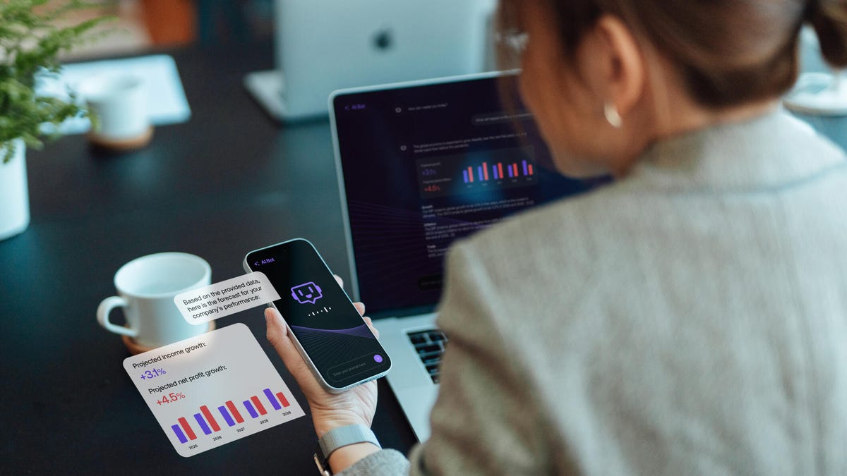 A photo of a woman using her phone and laptop at a table, with AI icons and spreadsheets on both.