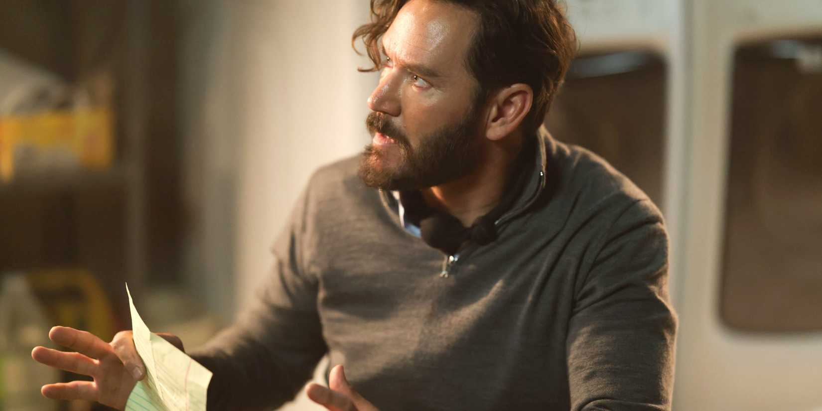 Hugh Sir Evans (Mark Paul-Gosselaar) holding a piece of paper and looking stressed out in Found