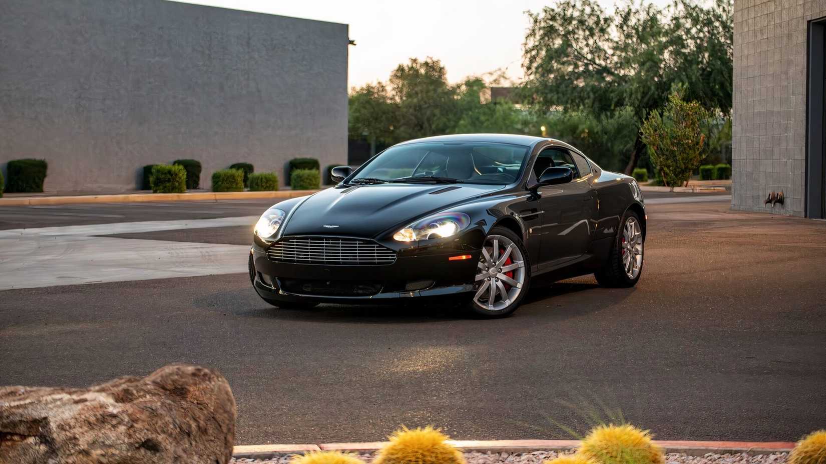 Black 2005 Aston Martin DB9 Coupe Parked With Lights On Front 3/4 View
