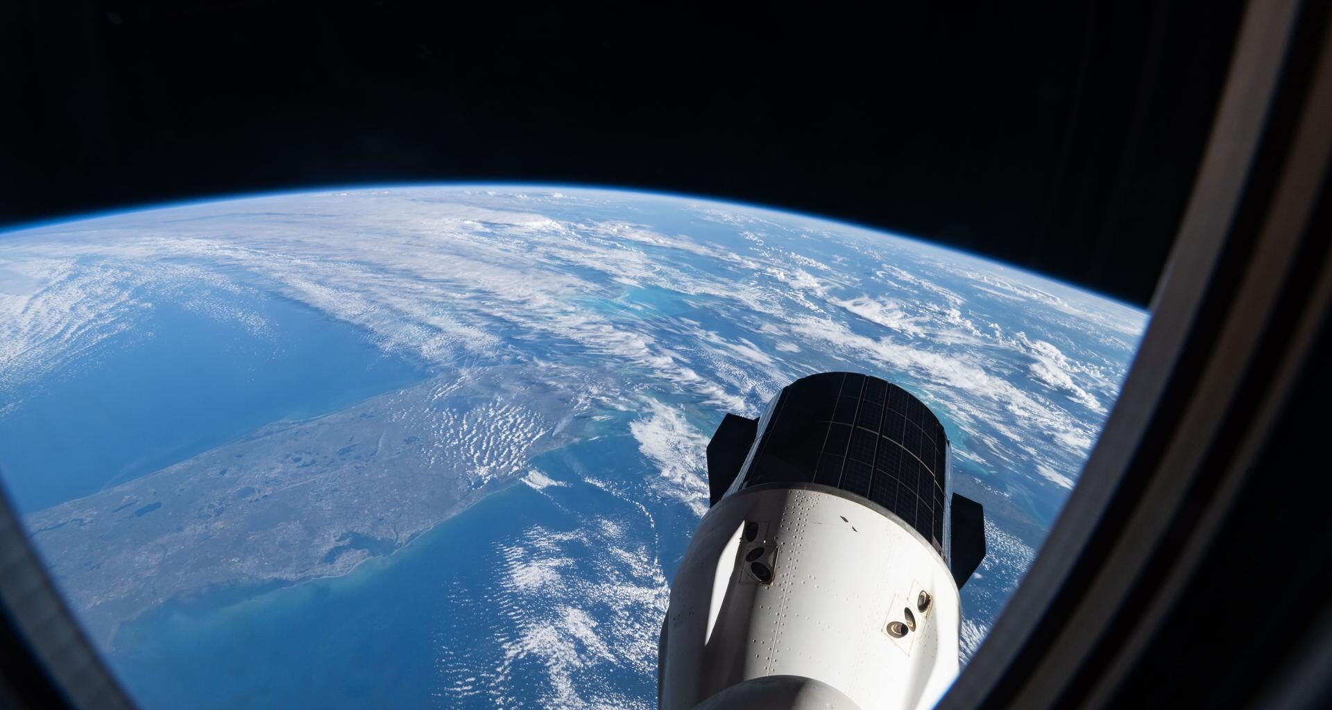 This photograph, taken from a window aboard the SpaceX Dragon crew spacecraft, shows the SpaceX Dragon cargo spacecraft with southern Florida visible below as the International Space Station orbited 260 miles above the Gulf of America.