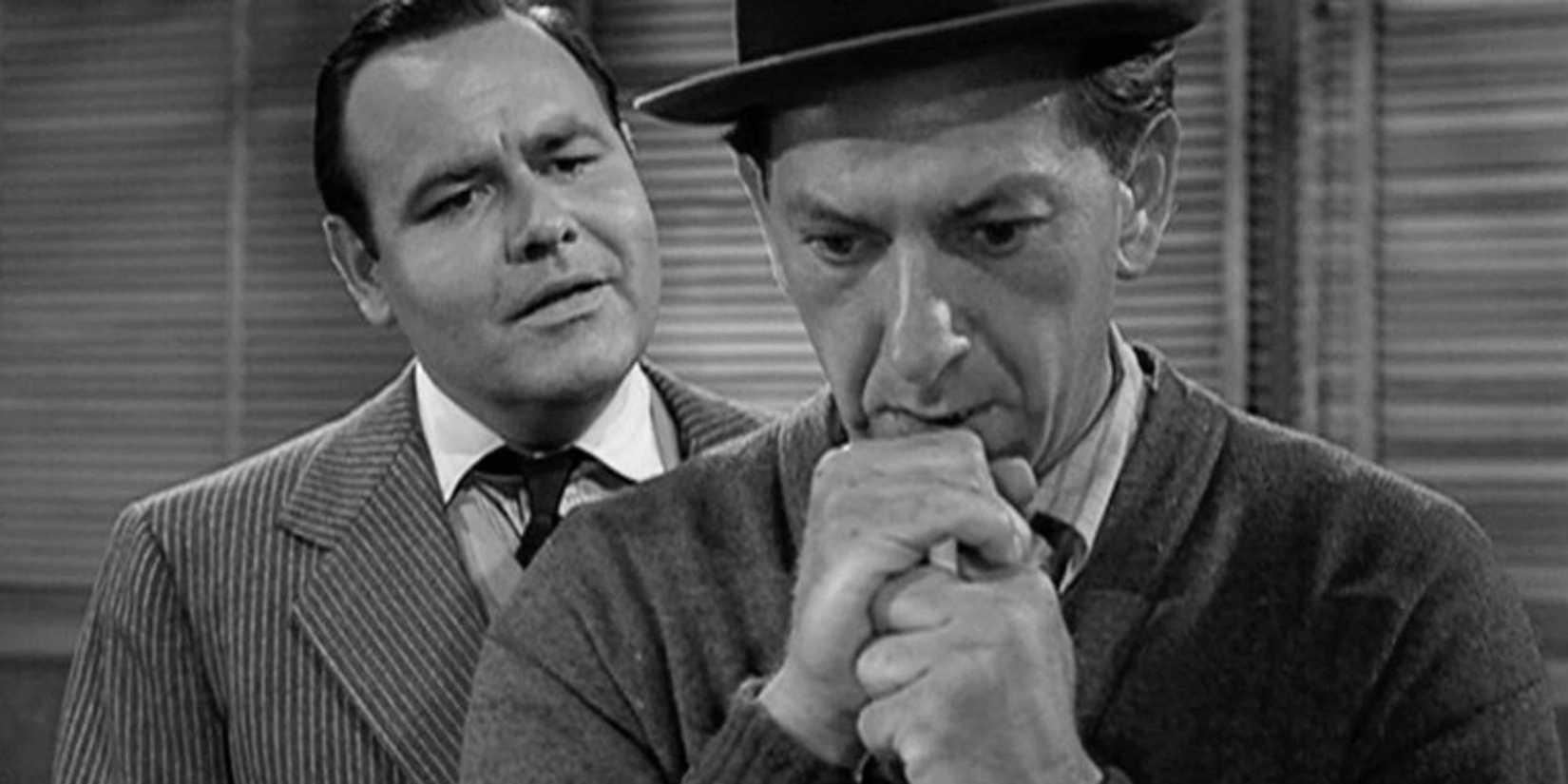 Jack Klugman holding a pole cue while resting his chin on his hands while Jonathan Winters is standing behind him in The Twilight Zone episode  A Game of Pool