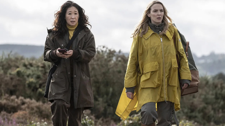 Eve Polastri (Sandra Oh) checks her phone as she walks outside with Villanelle (Jodie Comer) in Killing Eve
