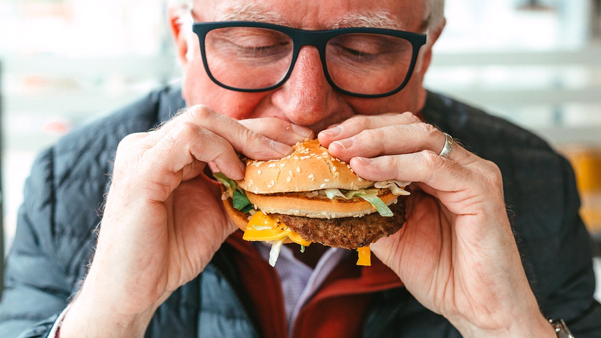 Old man eating burger