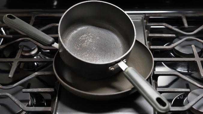 teflon coated pans stacked on stovetop