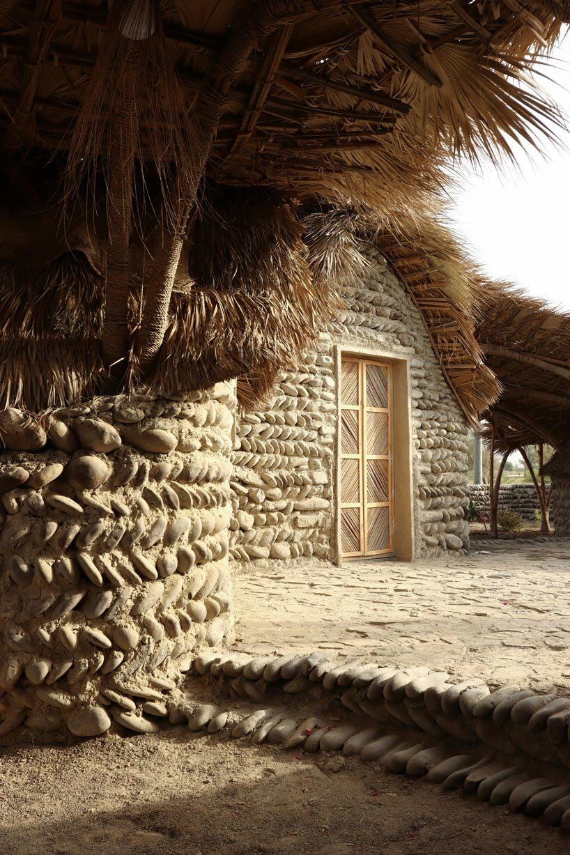 vaulted palm canopy shields dry stone guesthouse cluster in southeastern iran