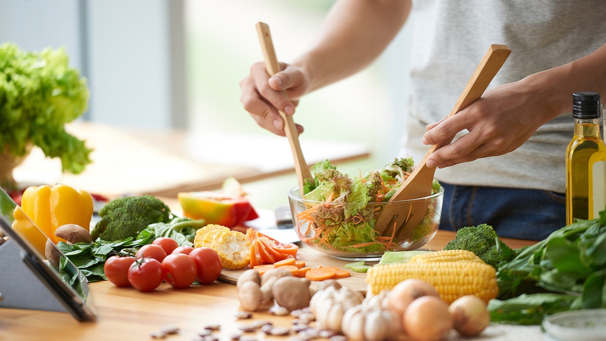 man mixing salad in bowl