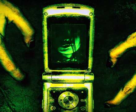 Two gnarled hands around a flip phone, bathed in an eerie yellow-green light in One Missed Call.