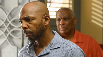 Close-up photo of Don Gilet in character as Detective Inspector Mervin Wilson. He looks serious as he stares at someone offscreen. 