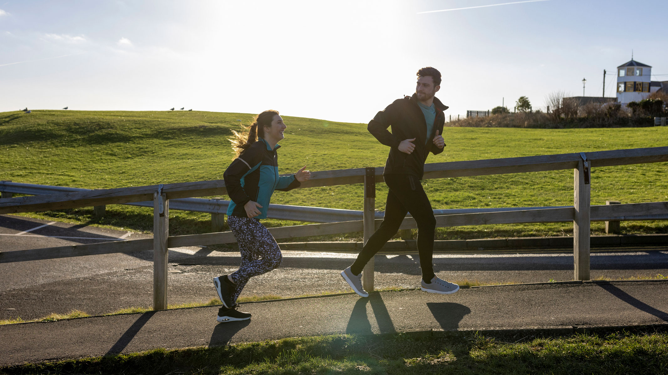 A picture of a couple running together in the countryside