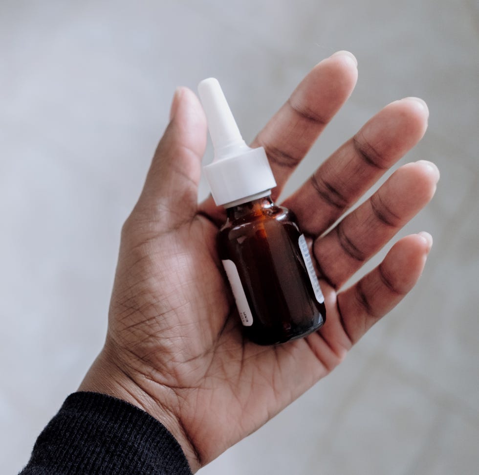 high angle view of unrecognizable black woman holding a bottle of prescription nasal spray