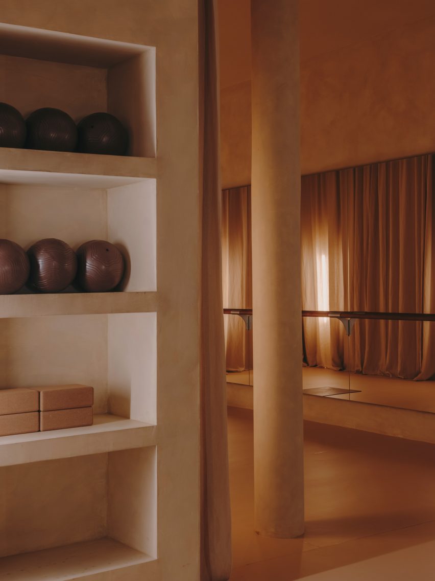 Barre studio with floor-to-ceiling curtains and mirrored walls