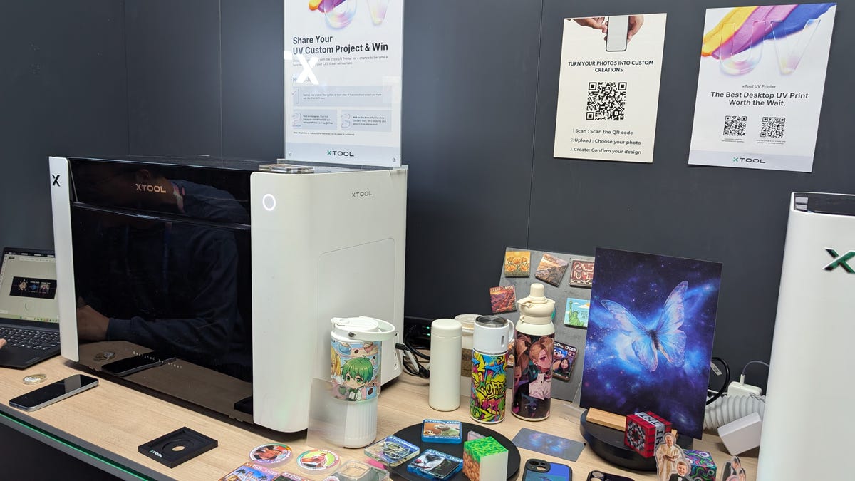 A white and black printer with printed materials all around it