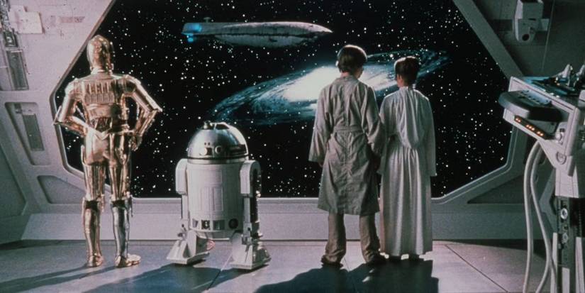 C3PO, R2-D2, Luke, an Leia with their back to the camera looking at the galaxy in The Empire Strikes Back.'