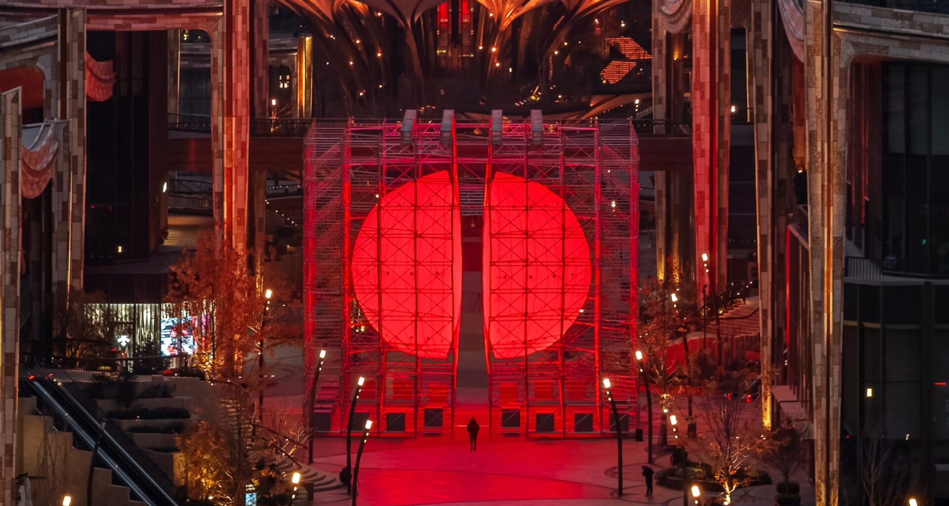 A large-scale installation by SpY of two glowing, red half-spheres within a metal framework