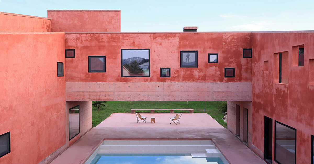 square openings punctuate the facade of red house in albania