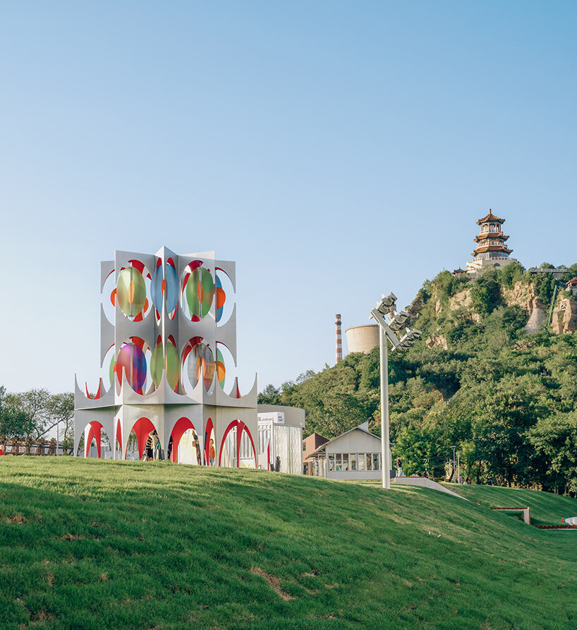 suspended colored discs move through daxing jizi design's faceted installation in beijing