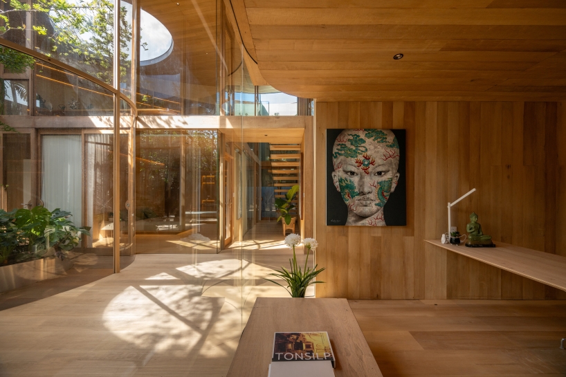 curved glass atriums penetrate residence’s aluminum roof in bangkok