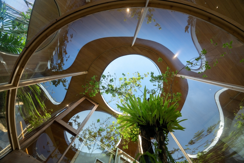 curved glass atriums penetrate residence’s aluminum roof in bangkok